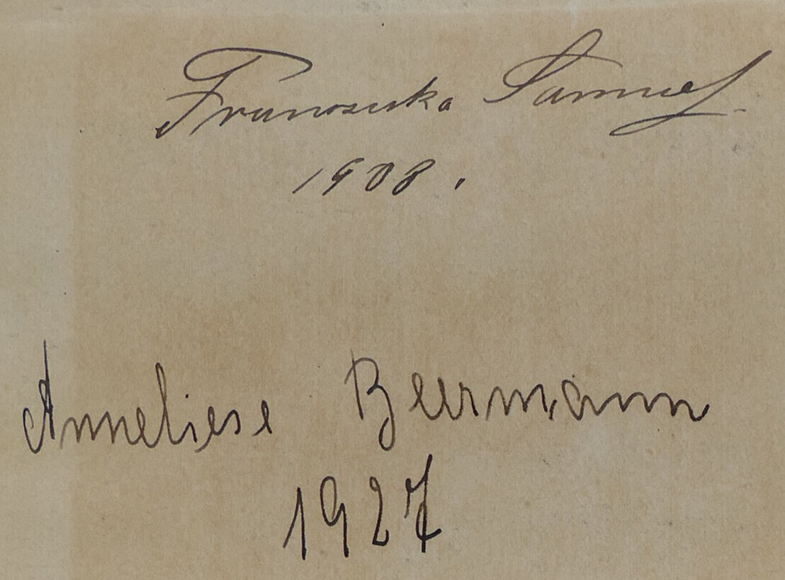 Man sieht ein Stück vergilbtes Papier mit zwei unterschriften darauf. Oben steh Franziska Samuel und darunter 1908. Dann mit etwas Abstand dazwischen weiter unten steht Anneliese Beermann und daraunter 1927