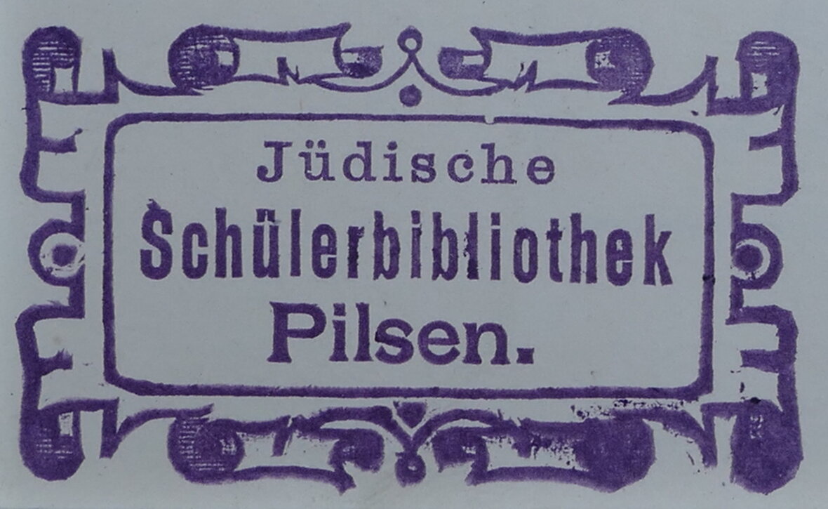 Stempel der Jüdischen Schüler Bibliothek Pilsen. Alles in Lila Tinte und der Schrift zug wird von einem rechteck und dieses wiedervoll von einem kunstvollen Rahmen umrundet.