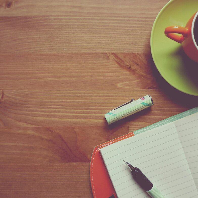 Tisch mit Block, Stift und Kaffee